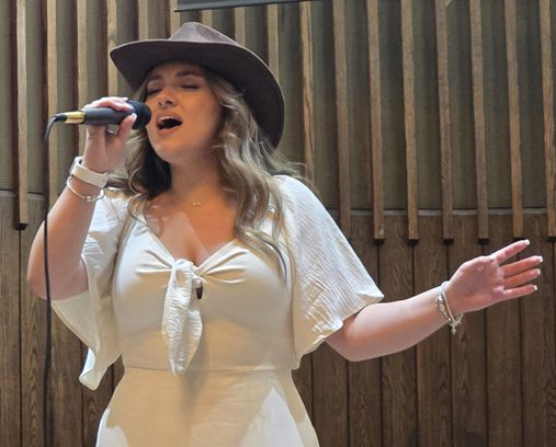 Teen performing a country song on stage at a music festival