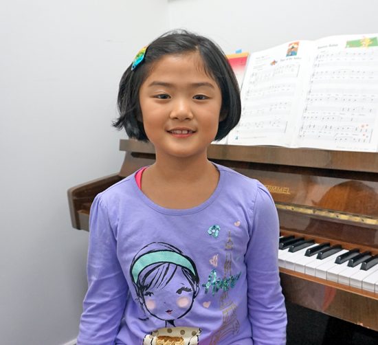 Young student smiling during a piano trial lesson